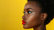 Portrait of a beautiful young dark-skinned woman with bold make-up and red lips. Side view. Yellow background.