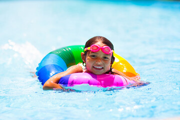 Wall Mural - Child in swimming pool on toy ring. Kids swim.