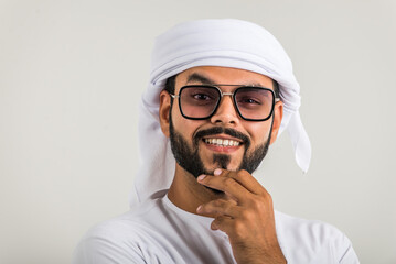 Handsome middle-eastern man wearing emirate traditional clothing portrait in studio