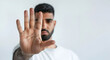 © Iryna - A man making a stop gesture with his hand against a white background. Copy space.