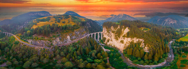 Wall Mural - Aerial view of Train passing through famous mountain in Filisur, Switzerland. Landwasser Viaduct world heritage with train express in Swiss Alps