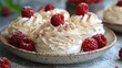   A close-up photo of a dessert in a bowl, featuring raspberries on the rim and the rest of the dessert in the background