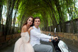 © Sergey - Wedding couple on a white scooter in a bamboo tunnel