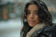 Portrait of beautiful smiling young woman with dark hair standing under snowing .