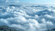   A panoramic view of numerous clouds against the backdrop of a majestic mountain range