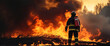 Silhouette of a fireman against the background of a large fire. Panorama.