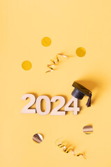 Wall Mural - Class of 2024 concept. Wooden number 2024 with graduated cap and confetti