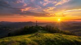 Fototapeta  - Cross perched on hill, glowing in setting sun's warmth