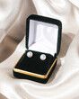 Pair of pearl earrings in velvet gift box on silk fabric