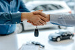 © Elena - Dealer giving key to buyer and shaking hands in auto show or salon. Concept of auto business, car sale, purchase or rent