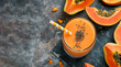 Papaya smoothie surrounded by fruits and papaya slices, top view, copy space. Papaya smoothie topped with chia seeds. Top view of fresh papaya smoothie with papaya halves and slices, dark background