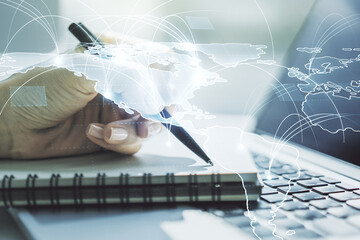 Poster - Double exposure of abstract digital world map with connections and hand writing in notepad on background with laptop, big data and blockchain concept