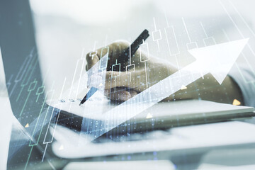 Poster - Multi exposure of abstract financial diagram with upward arrow and hand writing in notepad on background with laptop, rise and breakthrough concept