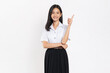Smiling student girl in university uniform hand pointing upward on white background.