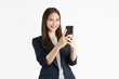 Beautiful Asian businesswoman holding smartphone and smiling on white background.