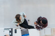 © qunica.com - Overhead shot capturing two colleagues in a casual business meeting discussing work. They're surrounded by modern office elements, showcasing a collaborative workspace environment.