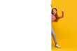 Girl giving thumbs up behind banner on yellow background