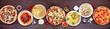 Delicious Italian food table scene. Variety of pizzas and pastas. Above view on a dark wood banner background.