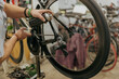 Close up of repairman is lubricate the bike chain in workshop. High quality photo