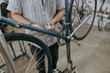 Close up of serviceman repairing modern bike using special tool while working in workshop