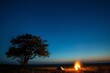 A campfire illuminates the night sky in the middle of a grassy plain. Generative AI