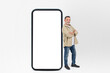Smiling man standing with giant smartphone, mockup
