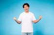 Excited young guy celebrating success on blue background