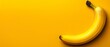   Close-up of a banana against a yellow backdrop, with its shadow casting on the side