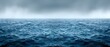   A vast expanse of water in the ocean, dotted with numerous waves, under overcast skies