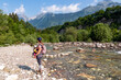 Woman with baby carrier with scenic view of Soca River, Bovec, Triglav National Park,Slovenia. Magnificent Soca Valley in Julian Alps. Wanderlust in untamed Slovenian Alps. Hiking in alpine wilderness