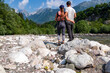 Loving hiker couple with scenic view of Soca River, Bovec, Triglav National Park, Slovenia. Magnificent Soca Valley in Julian Alps. Wanderlust in untamed Slovenian Alps. Hiking in alpine wilderness