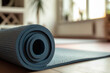 Blue rolled yoga mat laid on floor. Sport, yoga, pilates, fitness, useful beneficial habits, active lifestyle, exercises at home concept