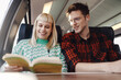 © Zamrznuti tonovi - Portrait of a young couple traveling by train and reading a book.