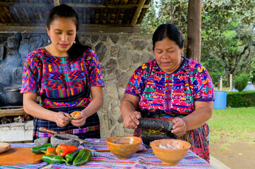 Sticker - Two women from the Mayan ethnic group prepare the food in an artisanal way.