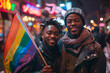 Interracial Gay Couple Holding Rainbow Flag on Busy City Street at Night
