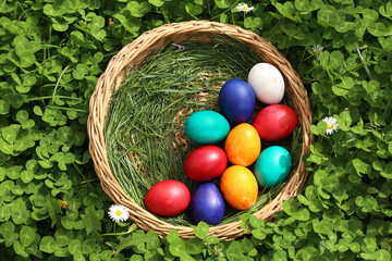 Closeup of colorful eggs in beautiful spring meadow on easter holiday outdoors in green graas.Traditional symbol for christian and catholic holiday