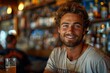 © Larisa AI - Cheerful young man with a bright smile sitting casually at a bar with a beer, displaying a laid-back vibe