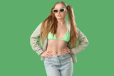 Fototapeta Panele - Beautiful young woman in stylish outfit on green background