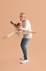 Sticker - Grandfather with his happy cute little grandson having fun together on beige background