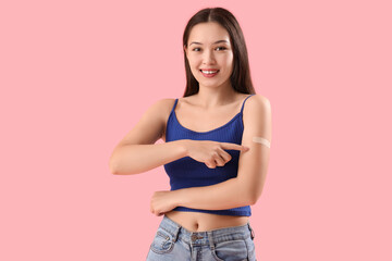 Sticker - Young woman pointing at applied medical patch on her arm against color background