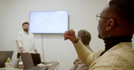 Wall Mural - Focused team members having an interactive discussion in a meeting room with a digital growth chart displayed on the screen.