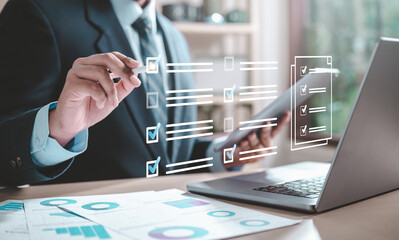 Wall Mural - file, list, checklist, chart, graph, management, marketing, report, strategy, information. A man is drawing on a laptop screen with a pen. Concept of focus and productivity to complete a task.