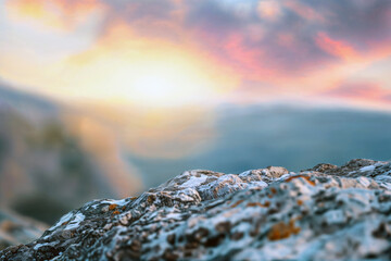 Wall Mural - sunrise over mountain range with foreground rocky texture and blurred background with copy space. pe