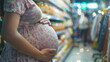 a pregnant woman holding her belly and shopping for baby products