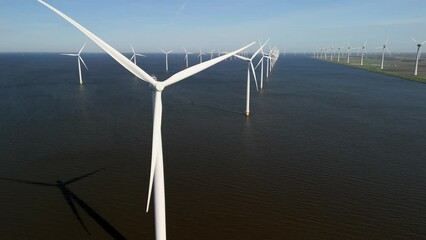 Wall Mural - close up drone aerial view of windmill turbines generating green energy electrically, windmills isolated at sea in the Netherlands at Spring