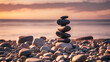 Pyramid of the small pebbles on the beach. Stones, against the background of the sea shore during sunset,
