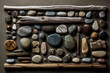 Assortment of varied stones and driftwood arranged in a grid pattern on a textured surface.