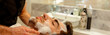 A relaxing moment at the spa portrayed with a man receiving a facial treatment, his face covered in foam, evoking a sense of calm and personal care. Banner. Copy space