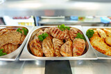 Fototapeta Na sufit - Grilled Chicken Breasts and Pork Cutlets Served in a Buffet Setting