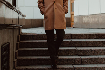 Poster - Man walking alone in the city, fashion details of beige brown men's coat and black turtleneck. Classic street outerwear